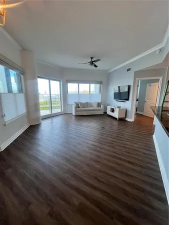 a view of an empty room with window and wooden floor