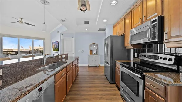 a kitchen with stainless steel appliances granite countertop a stove a sink and a refrigerator