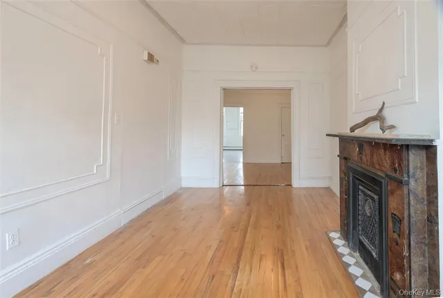 a view of empty room with wooden floor and fireplace