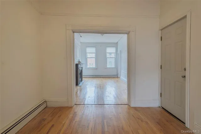 a view of a hallway with wooden floor and closet