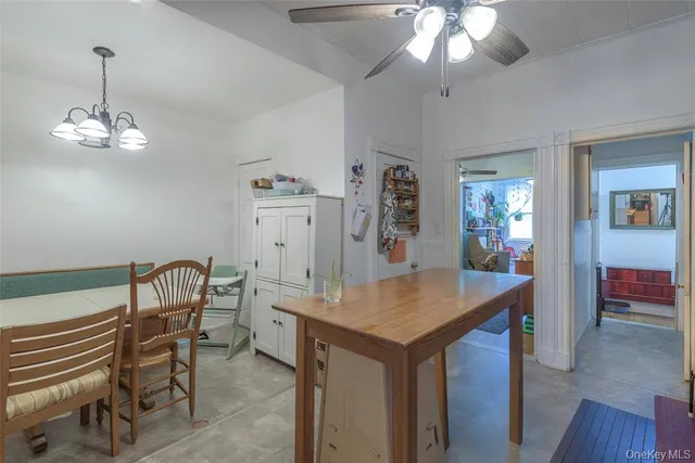 a room with a table chairs and chandelier