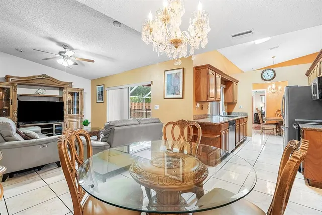 a living room with furniture a dining table and a chandelier