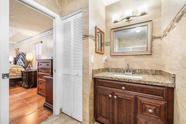 a bathroom with a granite countertop sink a vanity and a mirror