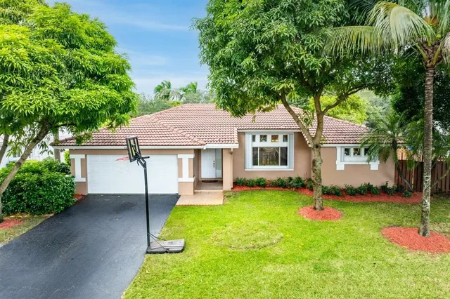 a front view of a house with a yard and trees