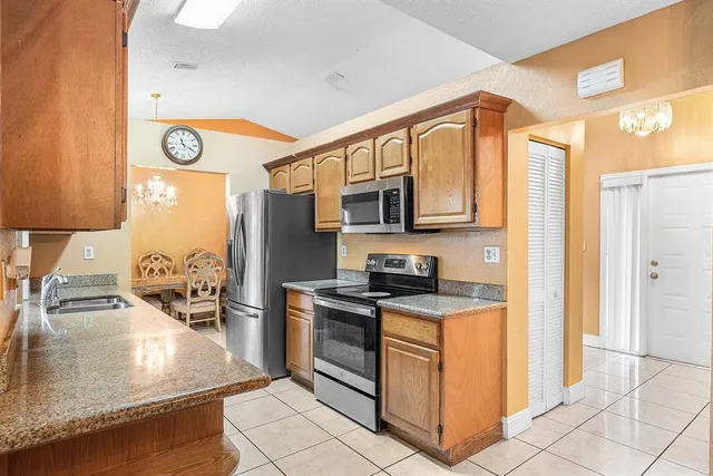 a kitchen with stainless steel appliances granite countertop a stove a sink and a microwave