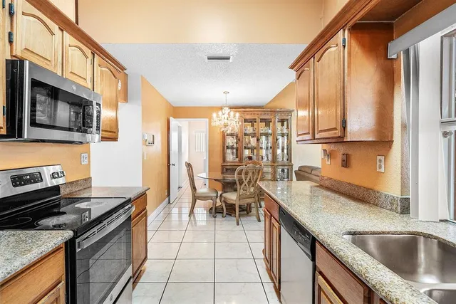 a kitchen with stainless steel appliances granite countertop a sink stove and cabinets