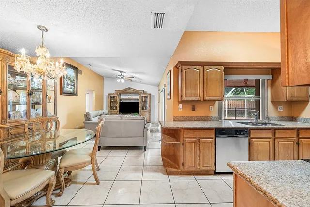 a living room with furniture a flat screen tv and kitchen view