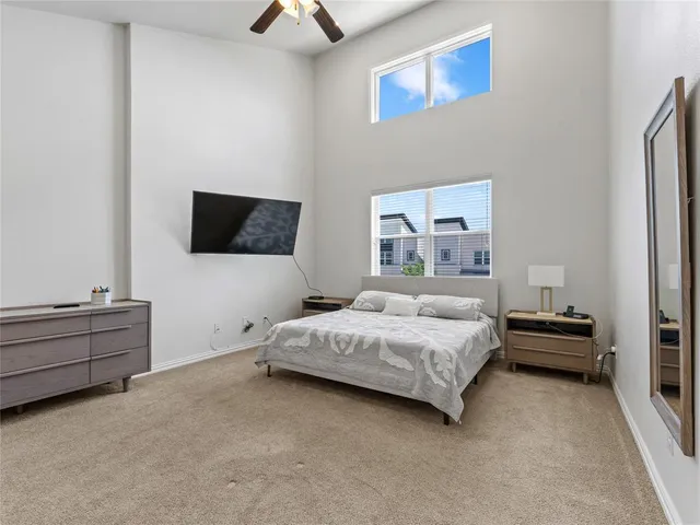 a spacious bedroom with a bed and a flat screen tv