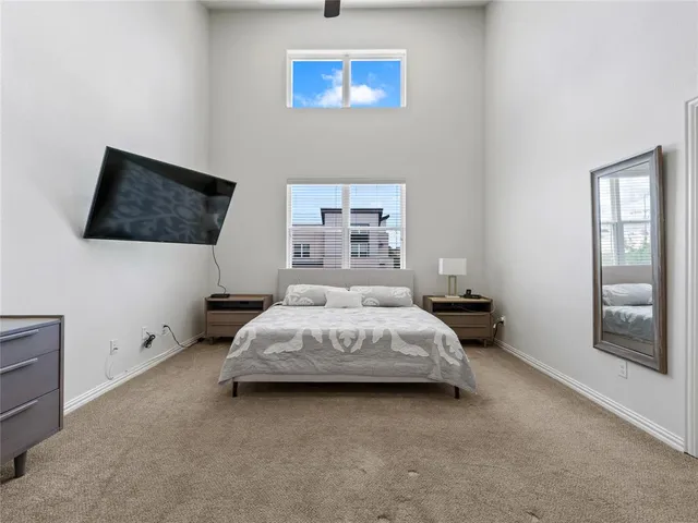 a spacious bedroom with a bed and a flat screen tv