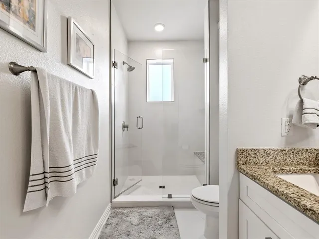 a bathroom with a granite countertop sink toilet and shower