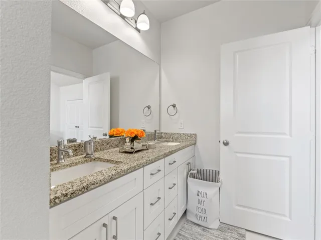 a bathroom with a granite countertop sink and a mirror