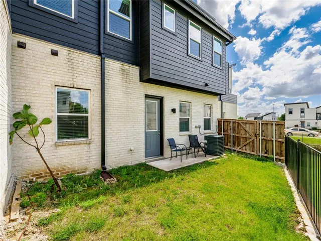 a view of a chair and table in backyard of the house