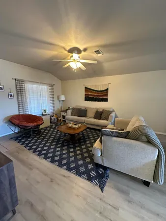 a living room with furniture and a chandelier
