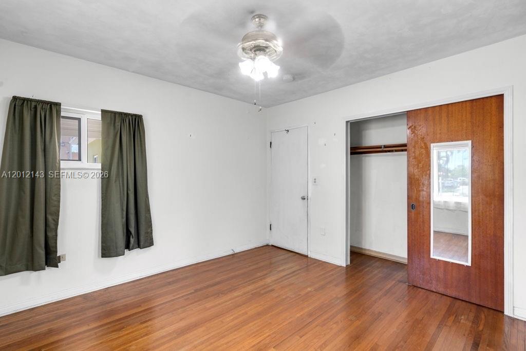 5651 Northwest 3rd Street Miami, FL 33126 - Photo 15 of 21 an empty room with wooden floor and a ceiling fan