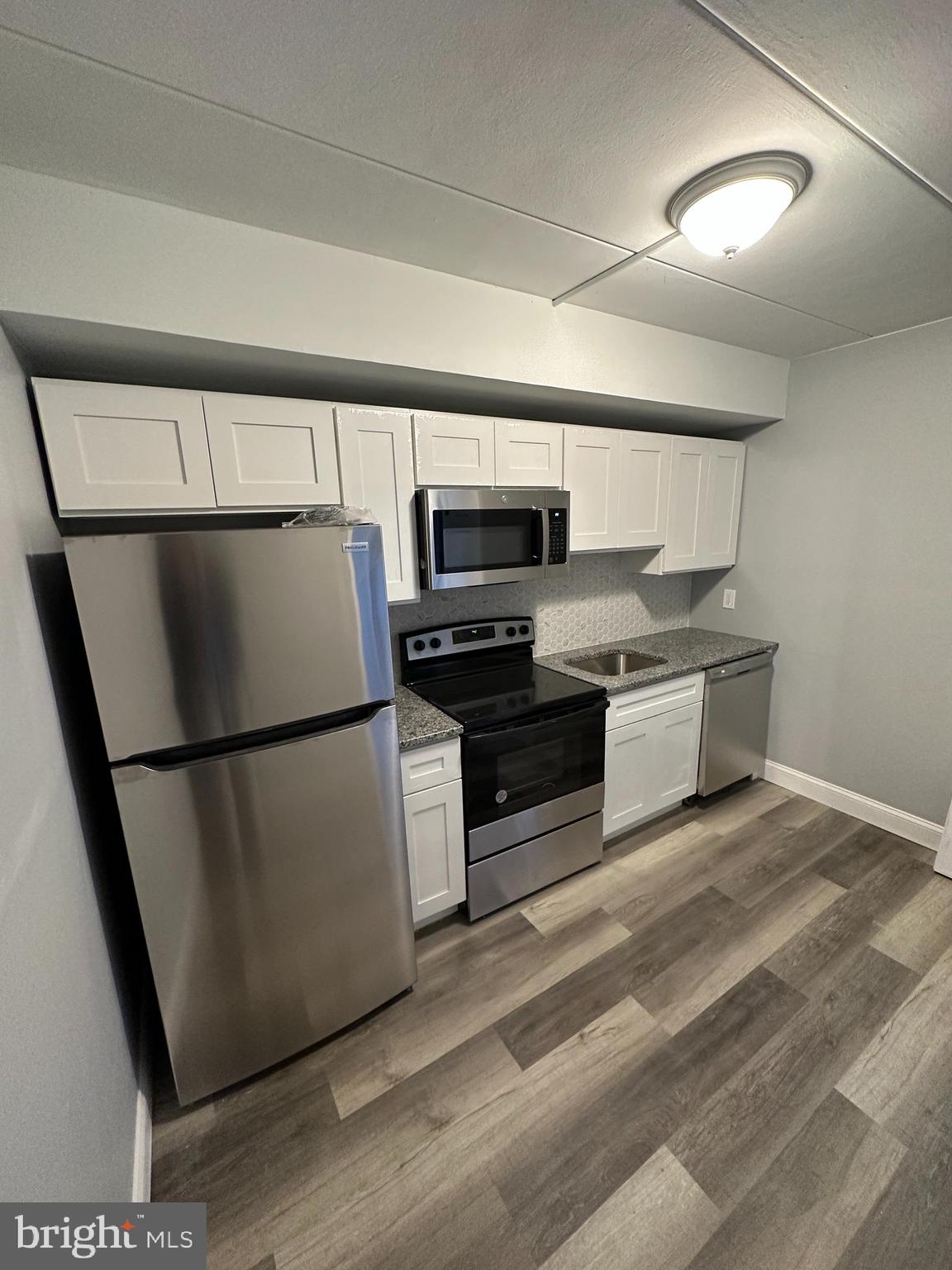 1575 West Street Road, Unit 922 Warminster, PA 18974 - Photo 15 of 16 a kitchen with stainless steel appliances a refrigerator sink and microwave