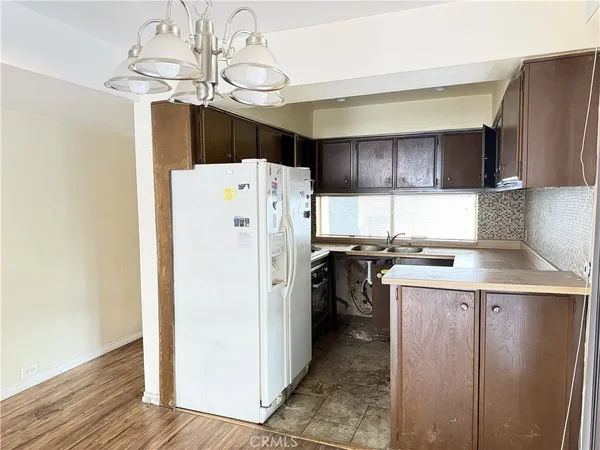 a kitchen with a refrigerator a sink dishwasher and a stove with wooden floor