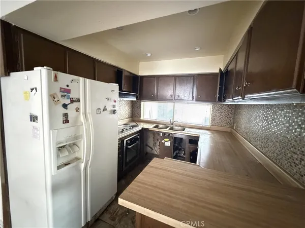 a kitchen with stainless steel appliances a refrigerator sink and cabinets