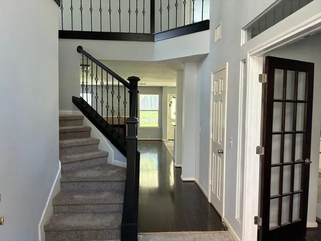 a view of staircase with lots of frames on wall and wooden floor