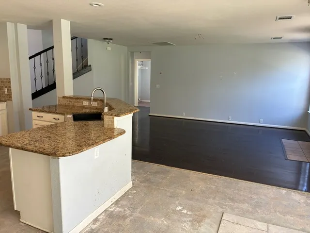 a kitchen with granite countertop a sink and a stove