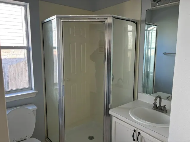 a bathroom with a shower a sink and a toilet