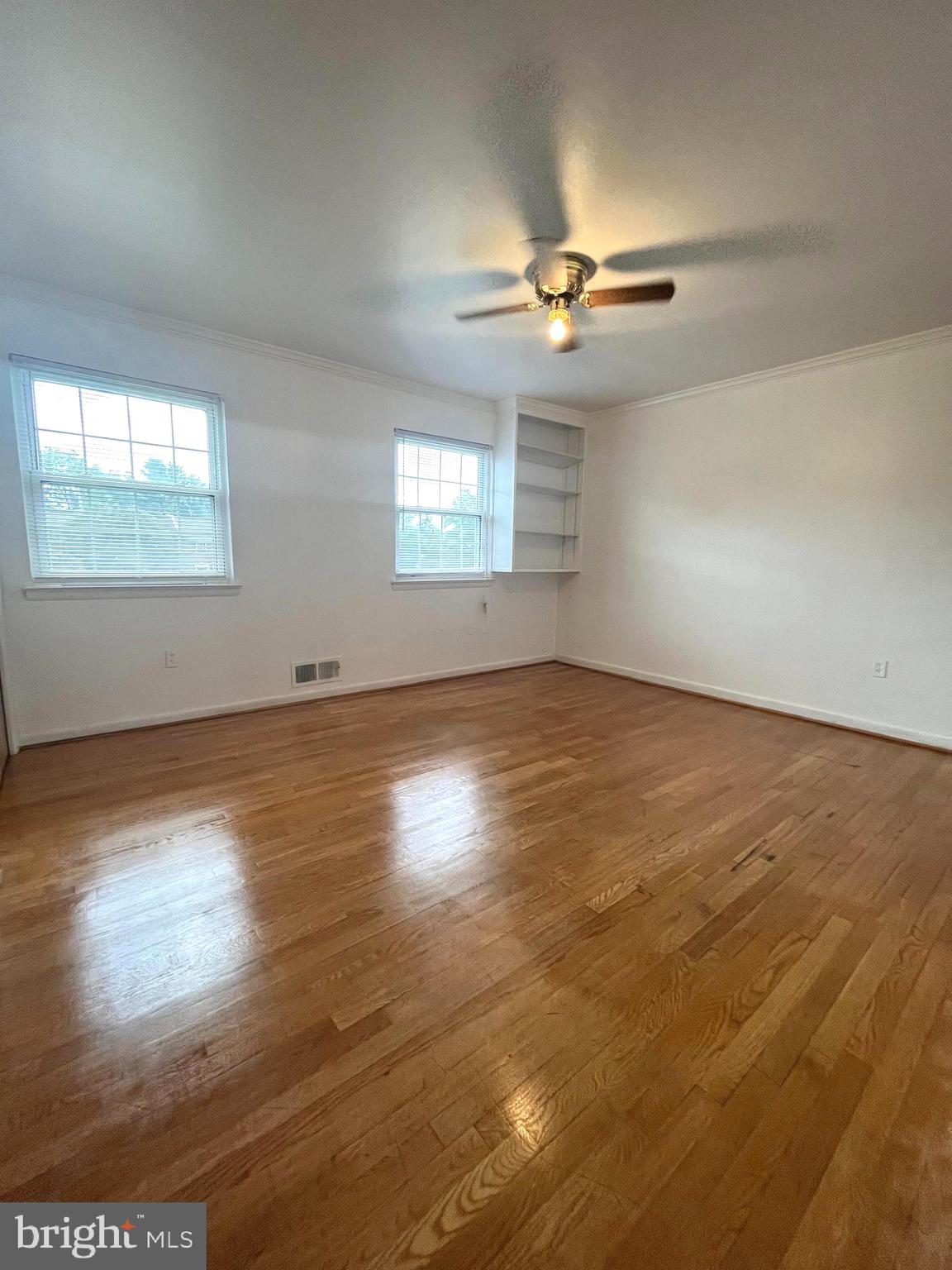 2943 Sunset Lane Suitland, MD 20746 - Photo 6 of 24 an empty room with wooden floor chandelier fan and windows