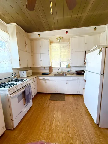 a kitchen with stainless steel appliances a stove a sink a refrigerator and a oven