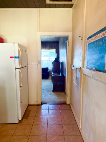 a view of living room with furniture and a refrigerator