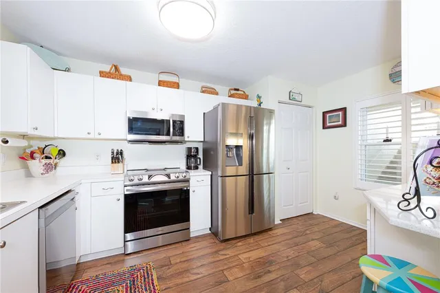 a kitchen with stainless steel appliances a stove a sink cabinets and a refrigerator