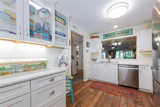 a kitchen with stainless steel appliances white cabinets and wooden floor
