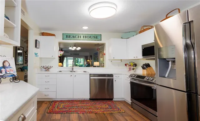 a kitchen with stainless steel appliances a refrigerator sink and microwave