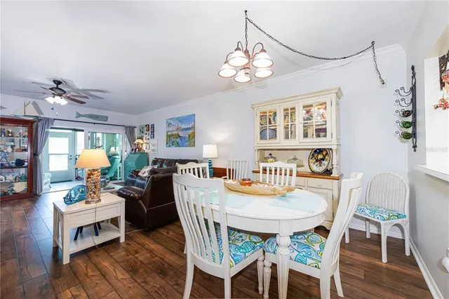 a view of a dining room with furniture a chandelier and wooden floor