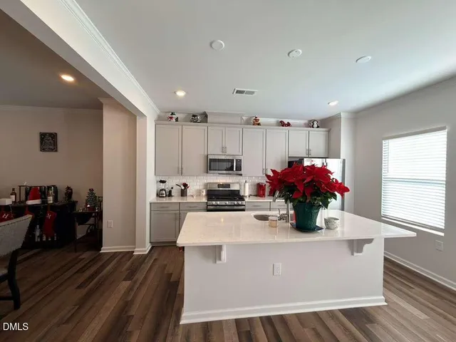 a living room with stainless steel appliances kitchen island granite countertop a stove and a refrigerator