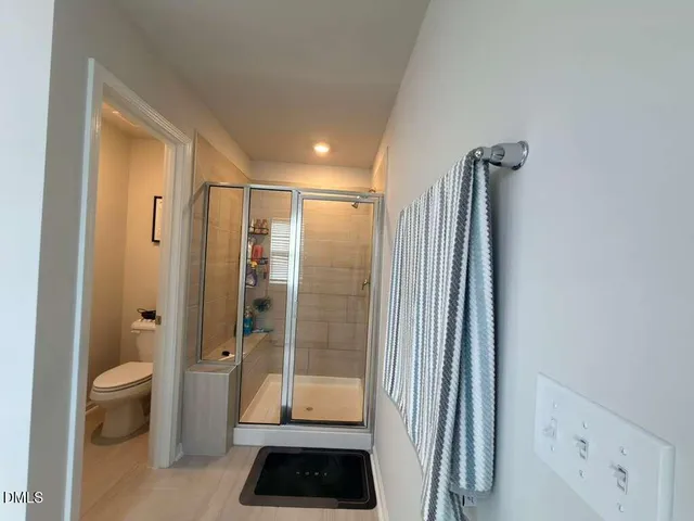 a bathroom with a shower a toilet and a sink