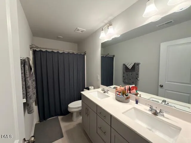 a bathroom with a sink vanity mirror and toilet