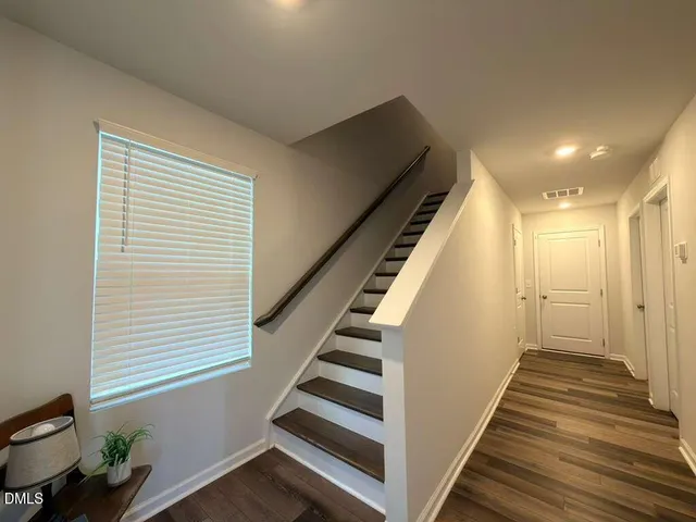 a view of a hallway with wooden floor and staircase