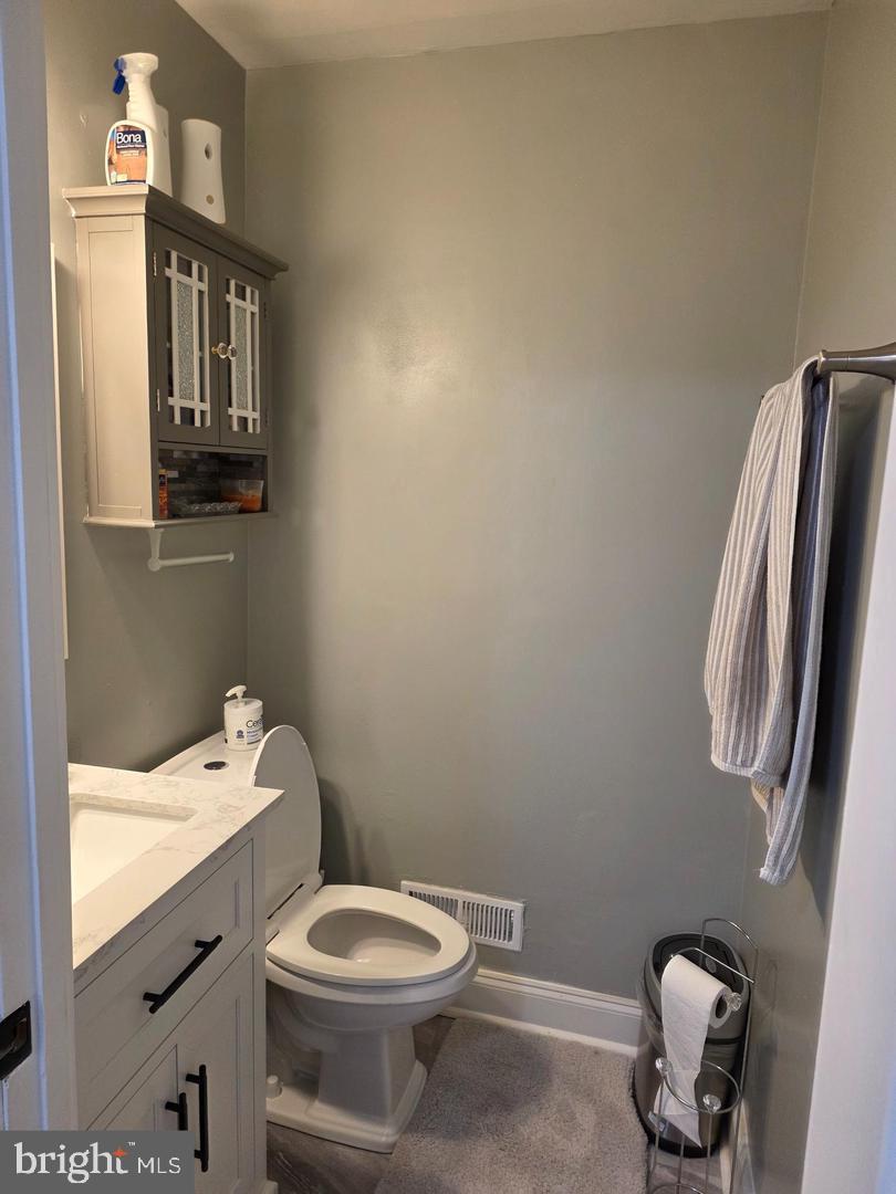1407 Adamsview Road Baltimore, MD 21228 - Photo 14 of 40 a bathroom with a toilet a sink and mirror