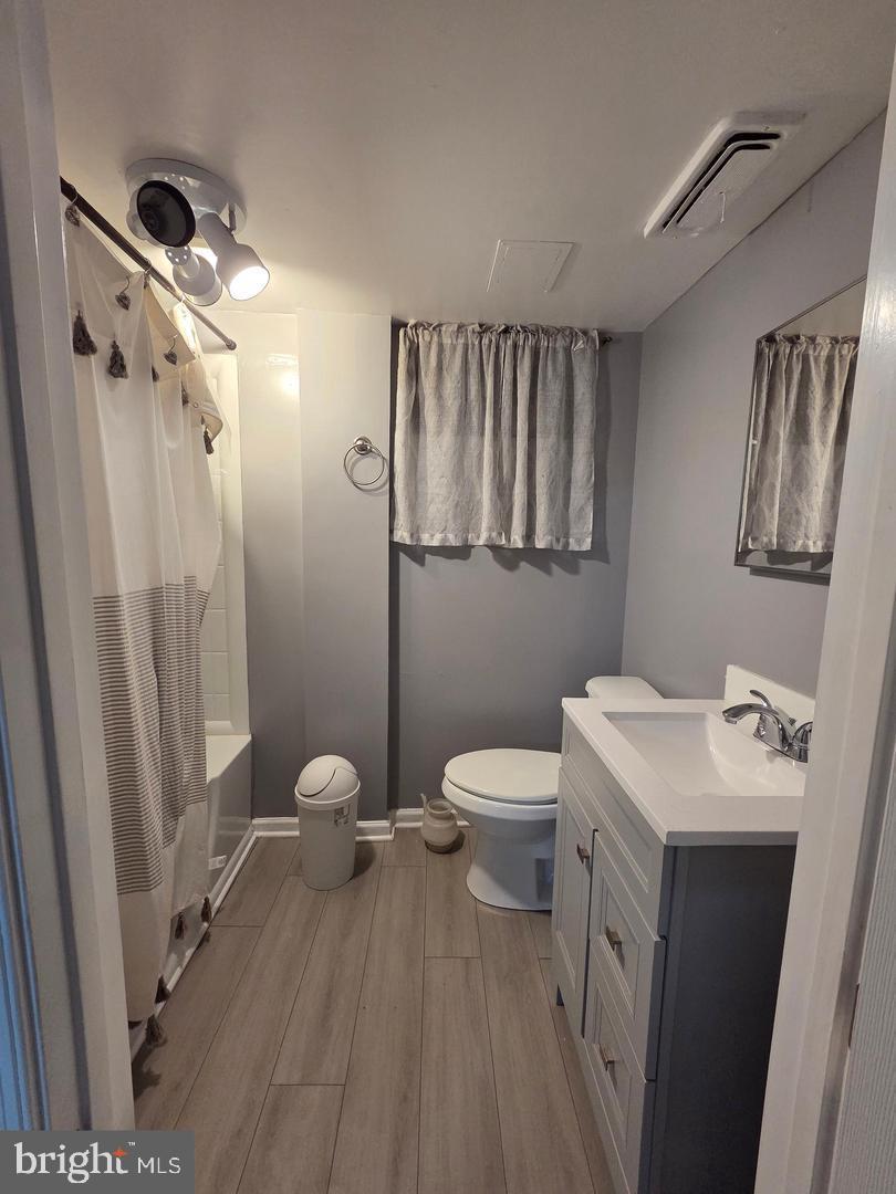 1407 Adamsview Road Baltimore, MD 21228 - Photo 37 of 40 a bathroom with a sink a toilet a mirror and shower