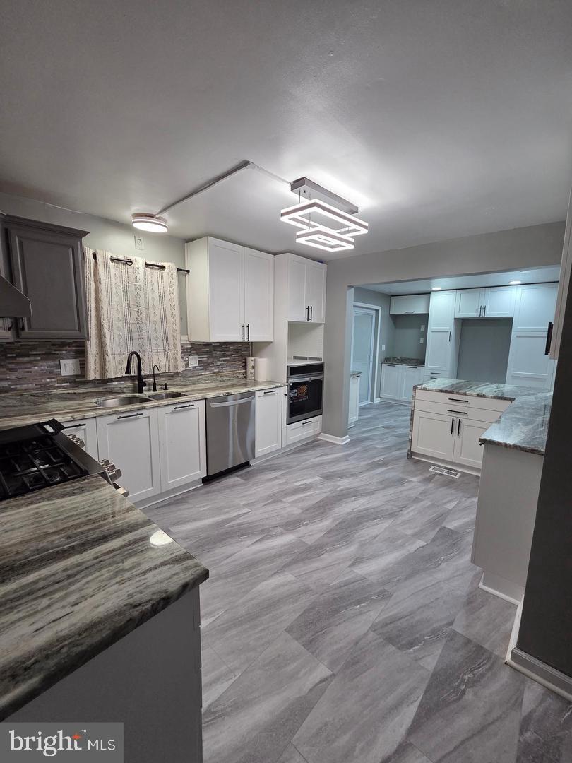 1407 Adamsview Road Baltimore, MD 21228 - Photo 40 of 40 a kitchen with a stove a refrigerator and a sink