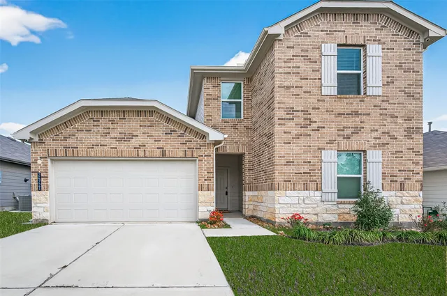 a view of empty room with wooden floor and kitchen view