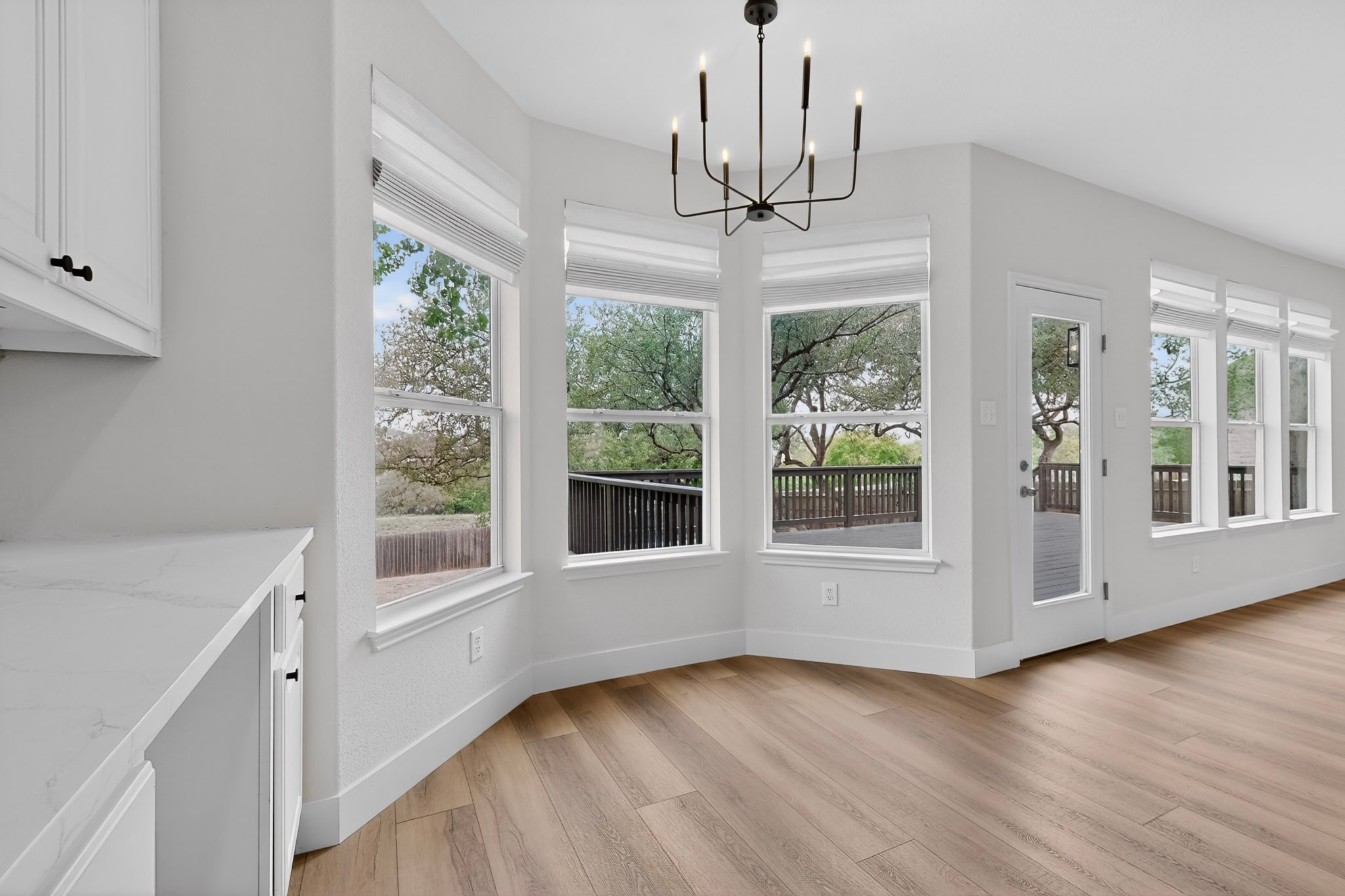 8617 Cobblestone Austin, TX 78735 - Photo 14 of 39 a view of an empty room with wooden floor exposed radiator and windows