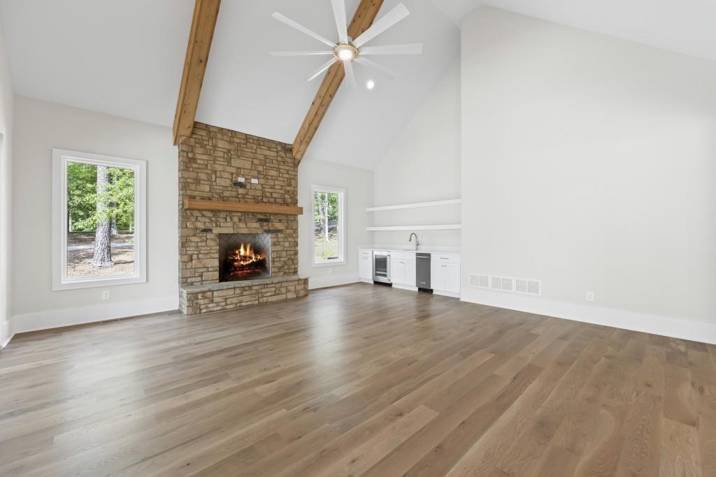 1301 Grayson Pointe Drive Buckhead, GA 30625 - Photo 11 of 56 an empty room with wooden floor fireplace and windows