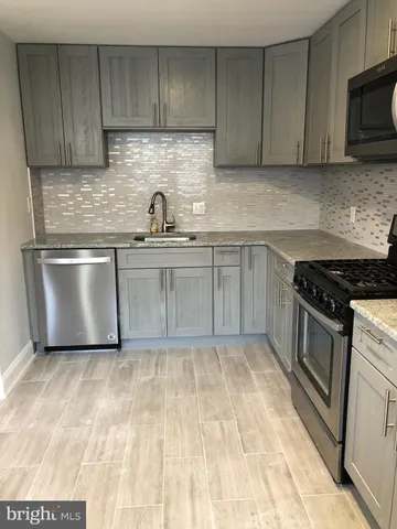 a kitchen with stainless steel appliances kitchen island a refrigerator and a sink