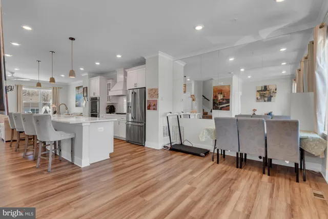 a living room with stainless steel appliances kitchen island hardwood floor and a view of kitchen