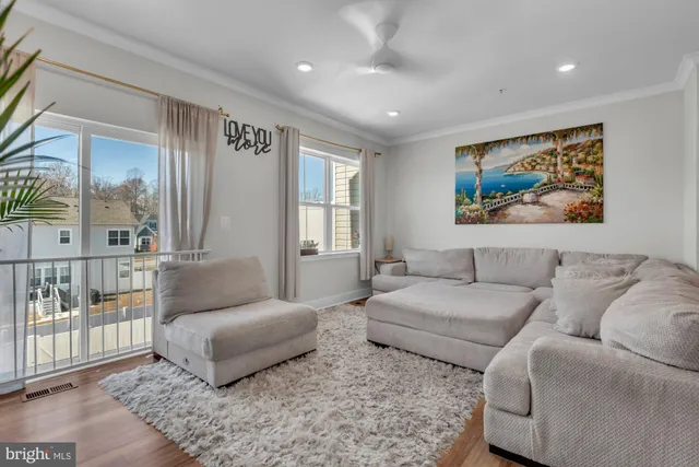 a living room with furniture and a view of kitchen