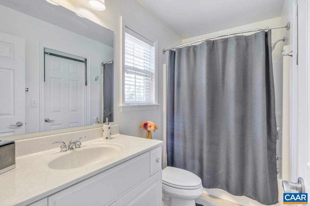 1915 Ridgetop Drive Charlottesville, VA 22903 - Photo 27 of 35 a bathroom with a sink a toilet a mirror and shower curtain