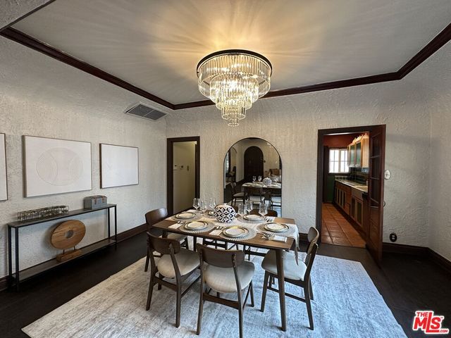 a view of a dining room with furniture a chandelier and wooden floor