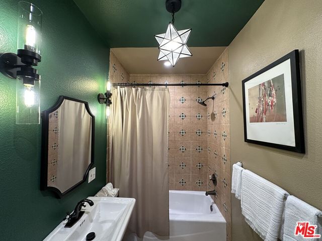 a bathroom with a sink a mirror and a shower