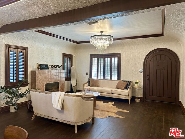 a living room with furniture wooden floor and a chandelier