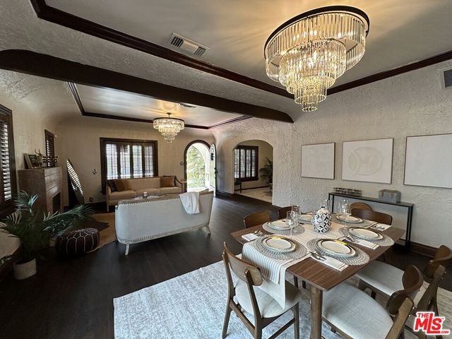 a view of a dining room with furniture a rug and wooden floor