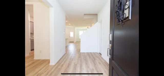 a view of a hallway with wooden floor